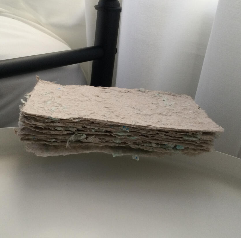 10 sheets of thicker textured cafe-coloured paper embedded with light green fabric scraps throughout