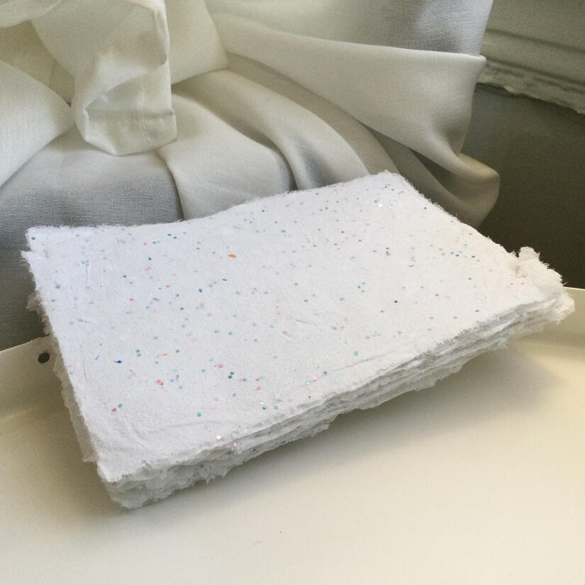stack of soft-textured handmade white papers with moderate amount of sparkles throughout